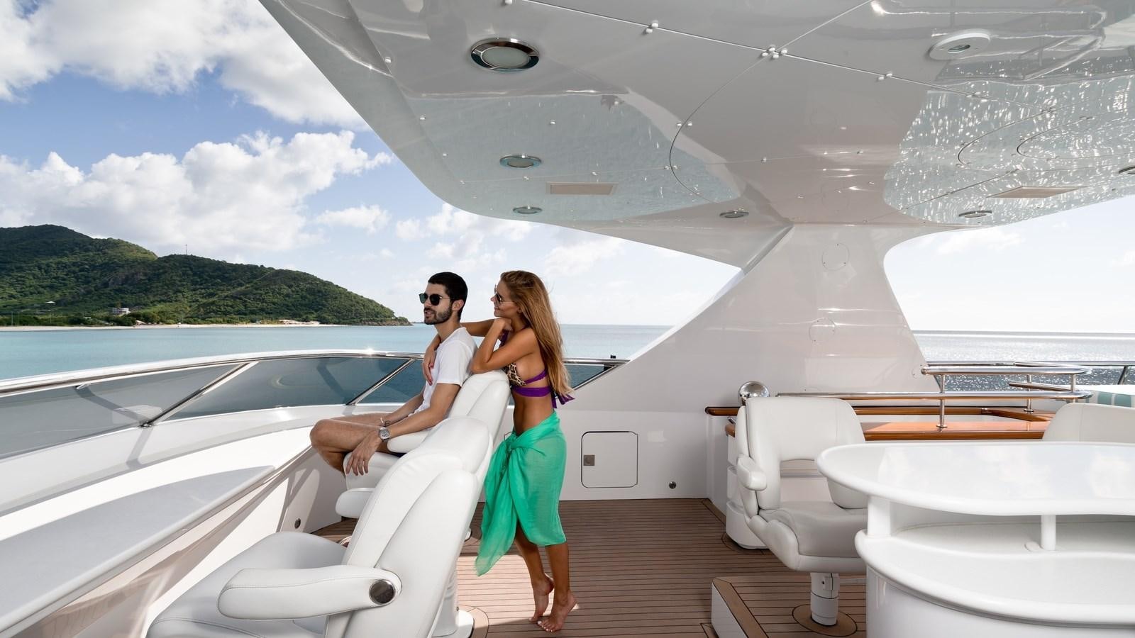 a man and woman sitting on a boat in the water aboard TOUCH Yacht for Sale