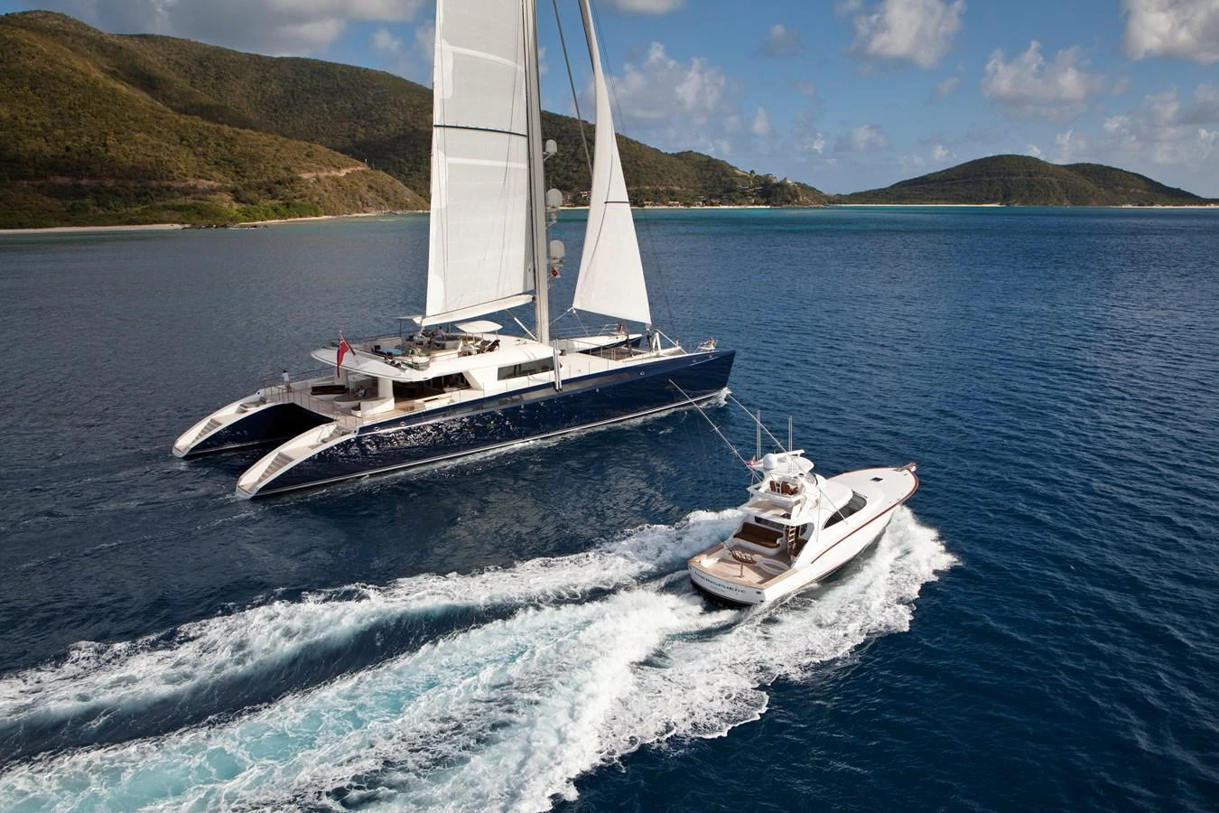 A stunning yacht sails gracefully on the open water, accompanied by a sleek tender boat. aboard HEMISPHERE Yacht for Sale
