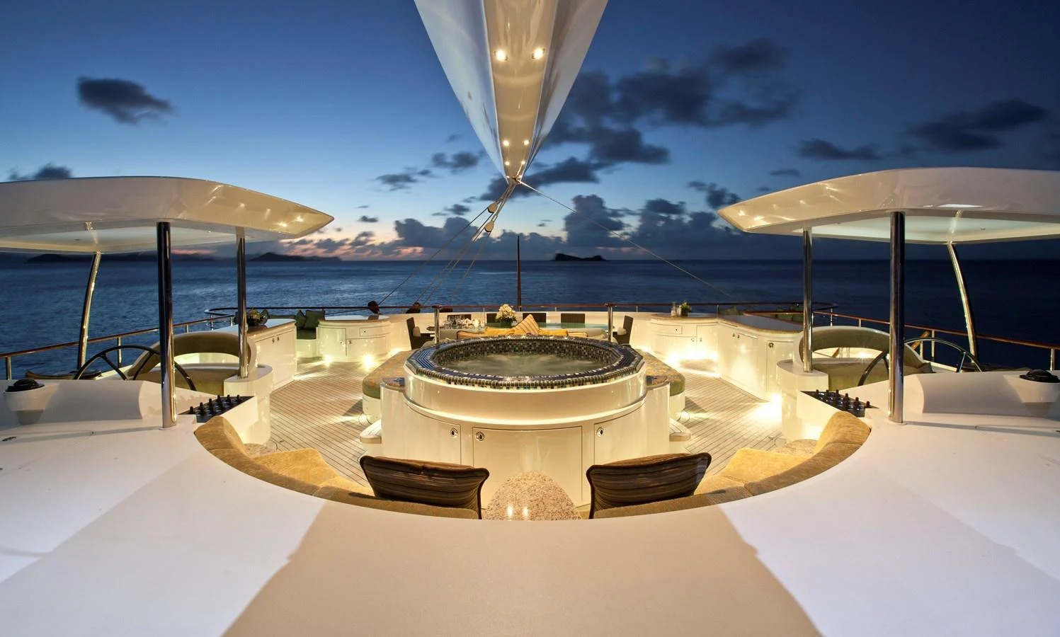 The sundeck features a luxurious hot tub with stunning ocean views at dusk. aboard HEMISPHERE Yacht for Sale