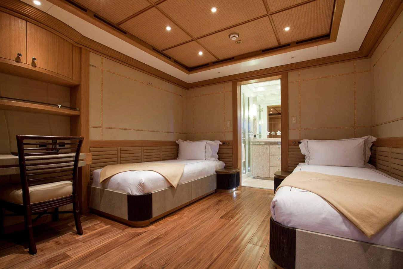 The guest stateroom features twin beds, warm wood finishes, and an ensuite bathroom. aboard HEMISPHERE Yacht for Sale