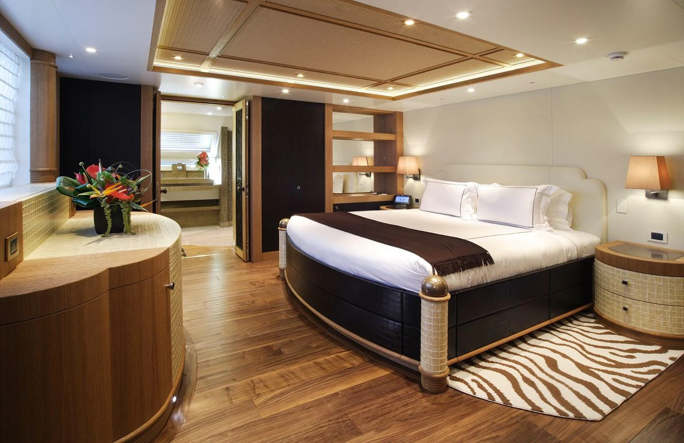 The master stateroom features a luxurious round bed and elegant wooden furnishings. aboard HEMISPHERE Yacht for Sale