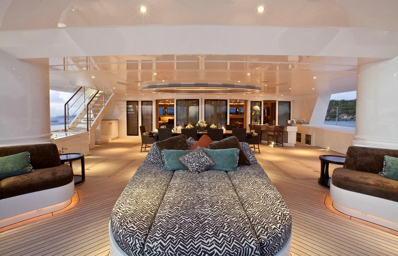 The aft deck features luxurious seating and dining areas with elegant lighting and decor. aboard HEMISPHERE Yacht for Sale