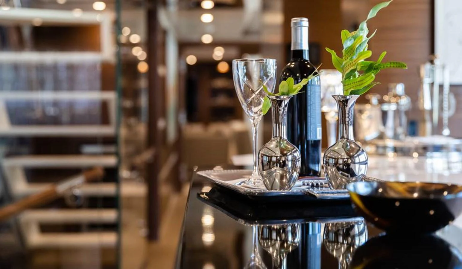 A luxurious interior setting featuring elegant table decor with wine and glassware. aboard NORTHLAND Yacht for Sale