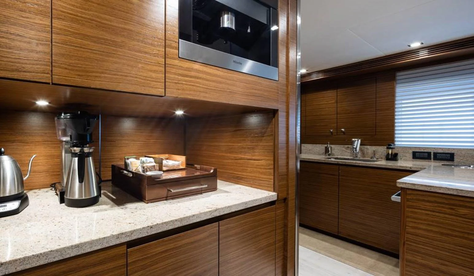 The yacht's galley features sleek wooden cabinetry and modern appliances, creating a stylish and functional space. aboard NORTHLAND Yacht for Sale