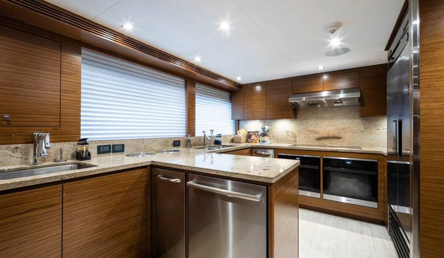 The galley features modern appliances and sleek wooden cabinetry, creating a warm and functional space. aboard NORTHLAND Yacht for Sale