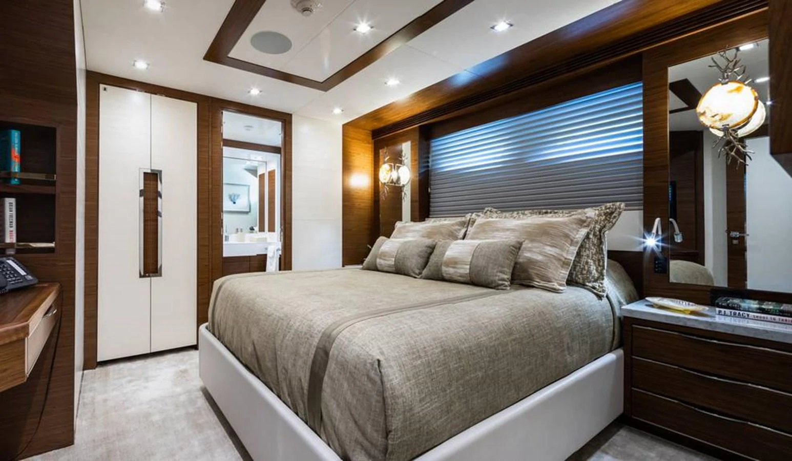 The master stateroom features a luxurious bed with elegant bedding and modern lighting. aboard NORTHLAND Yacht for Sale
