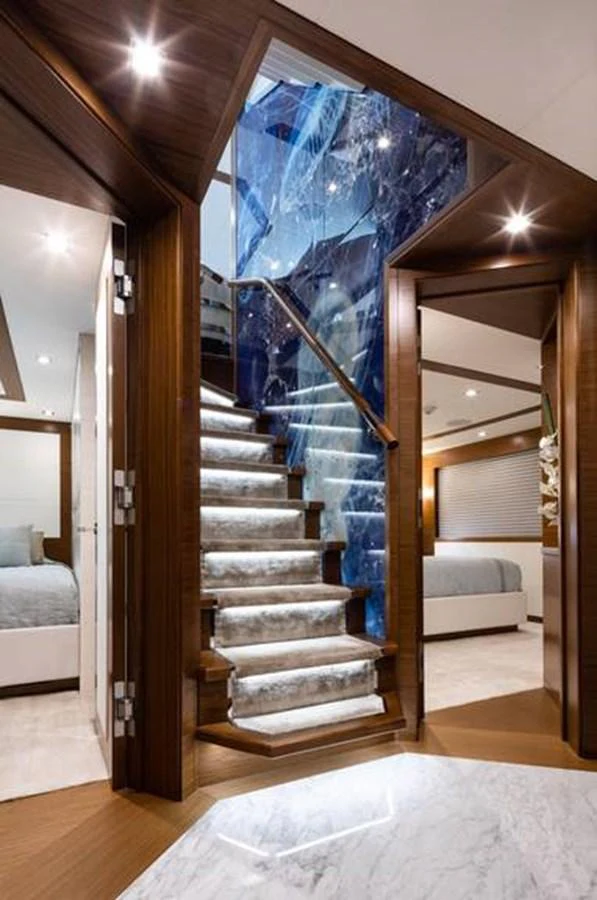 The interior features a luxurious staircase with marble steps and wooden accents, leading to a well-appointed living area. aboard NORTHLAND Yacht for Sale