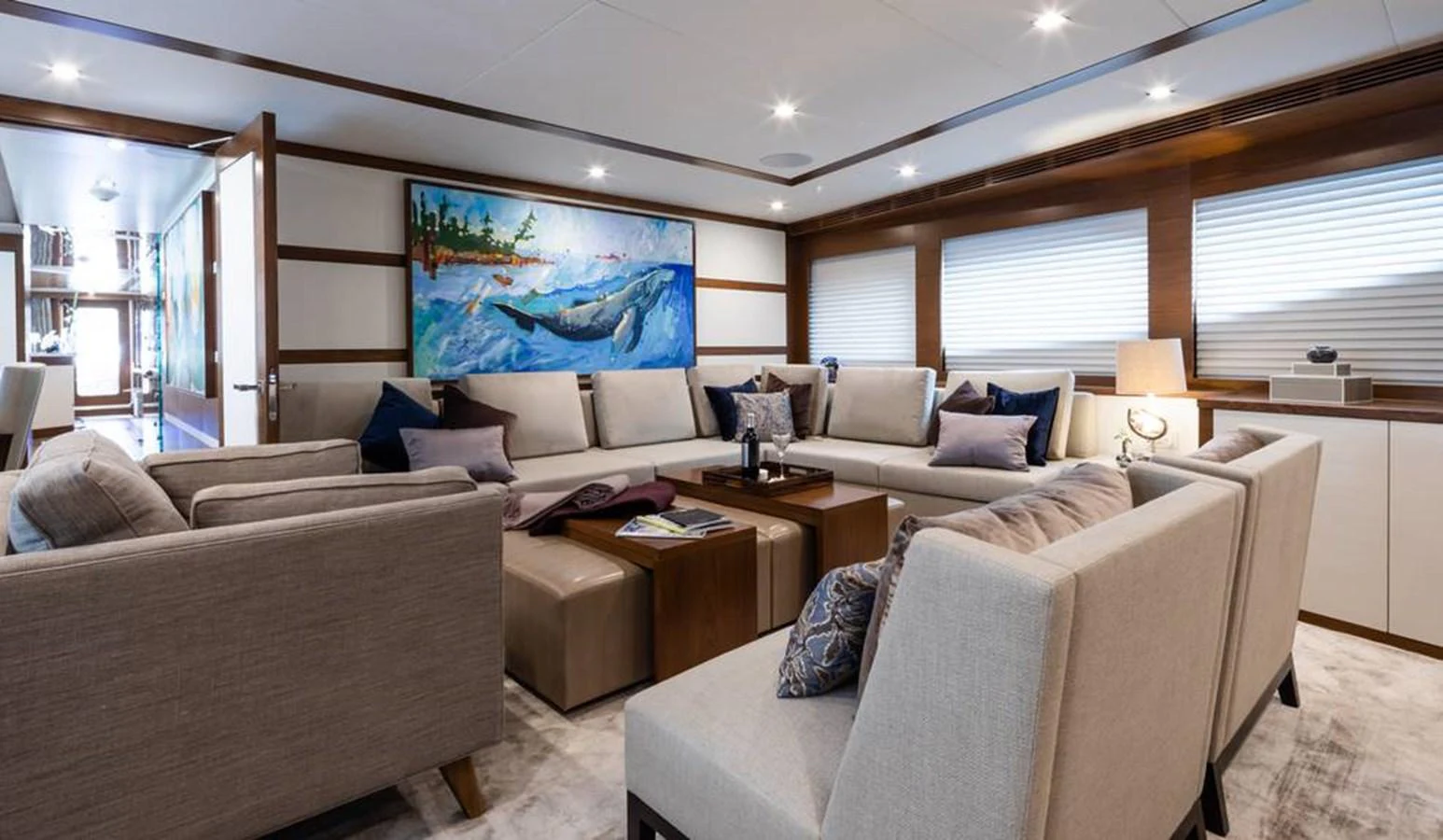 The salon features a spacious and elegant seating area with modern decor and a vibrant painting. aboard NORTHLAND Yacht for Sale