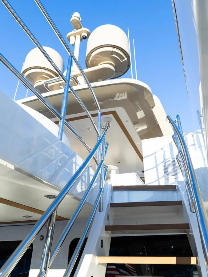 A modern yacht exterior featuring sleek railings and a staircase leading to the upper deck. aboard NORTHLAND Yacht for Sale