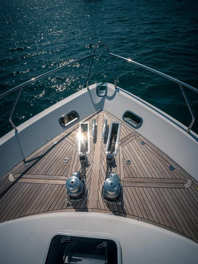 The bow of the yacht features polished stainless steel fittings and a sleek teak deck. aboard 4 LIFE Yacht for Sale