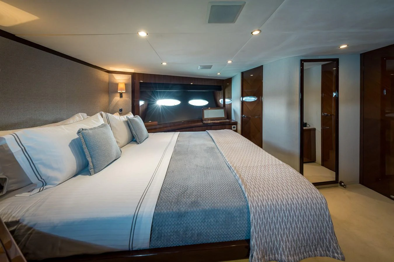 The master stateroom features a spacious bed with luxurious bedding and elegant wood finishes. aboard 4 LIFE Yacht for Sale