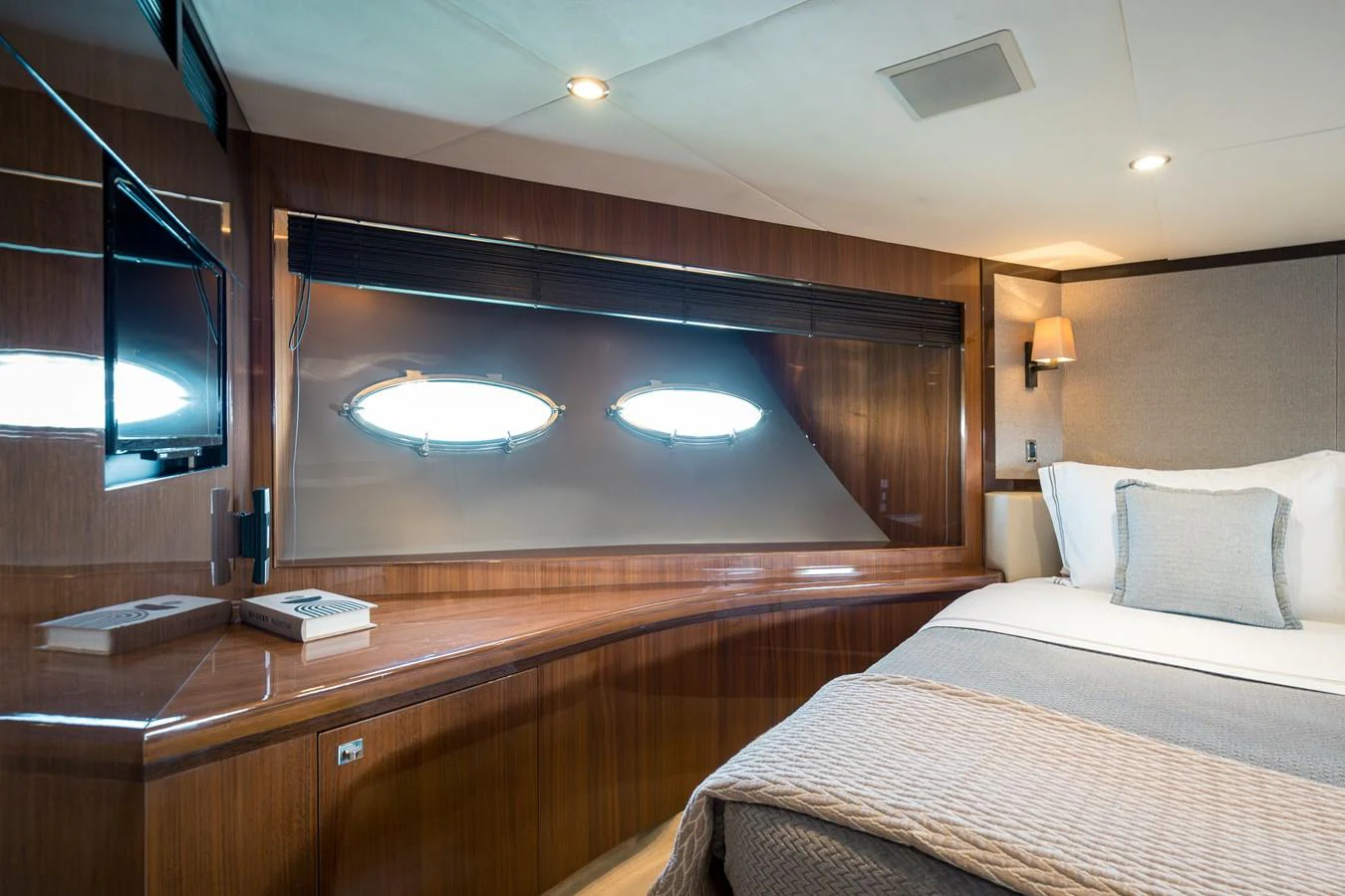 The stateroom features a cozy bed, a sleek wooden desk, and large windows for natural light. aboard 4 LIFE Yacht for Sale
