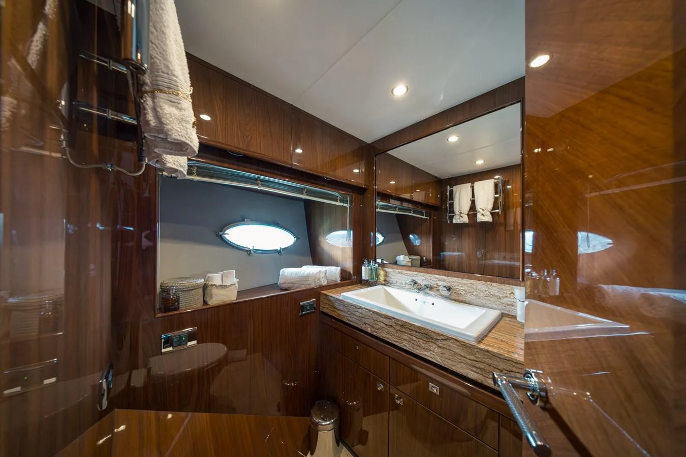 This elegant yacht bathroom features rich wood paneling and a spacious countertop with a large sink. aboard 4 LIFE Yacht for Sale