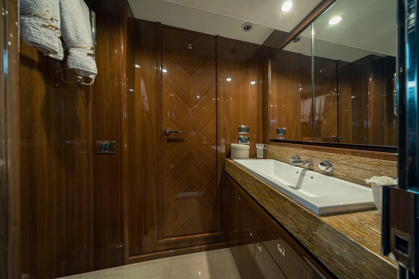 The yacht's bathroom features elegant wood paneling and a sleek, modern sink area. aboard 4 LIFE Yacht for Sale