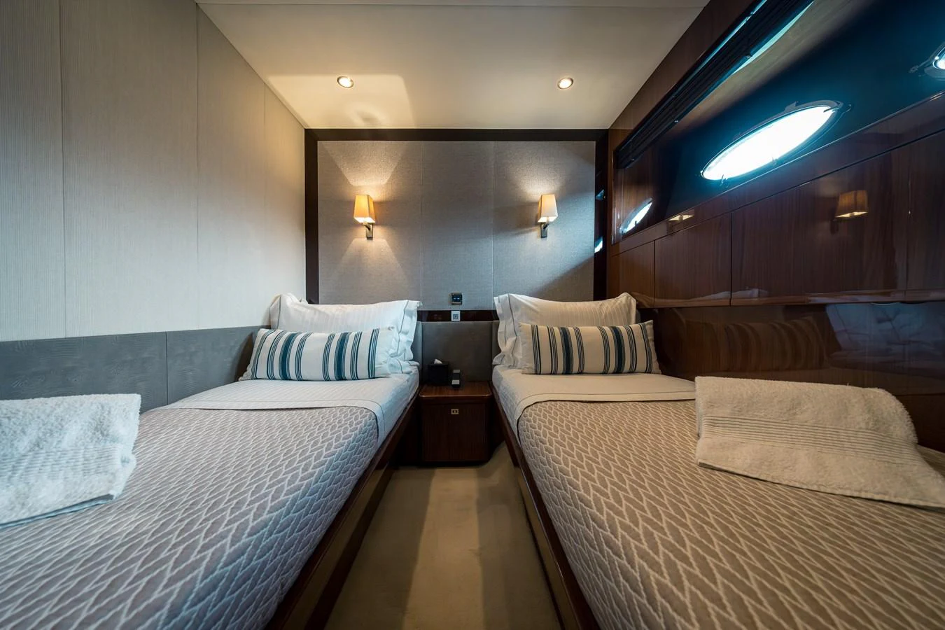 The twin stateroom offers a cozy and elegant sleeping area with two single beds and tasteful lighting. aboard 4 LIFE Yacht for Sale