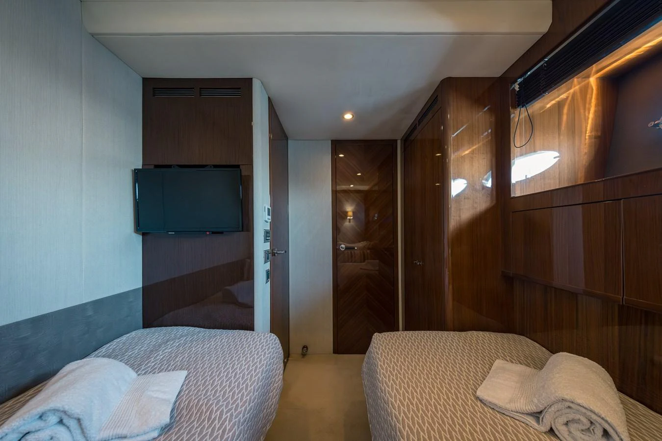 The twin stateroom offers a cozy and modern retreat with two single beds and a wall-mounted TV. aboard 4 LIFE Yacht for Sale