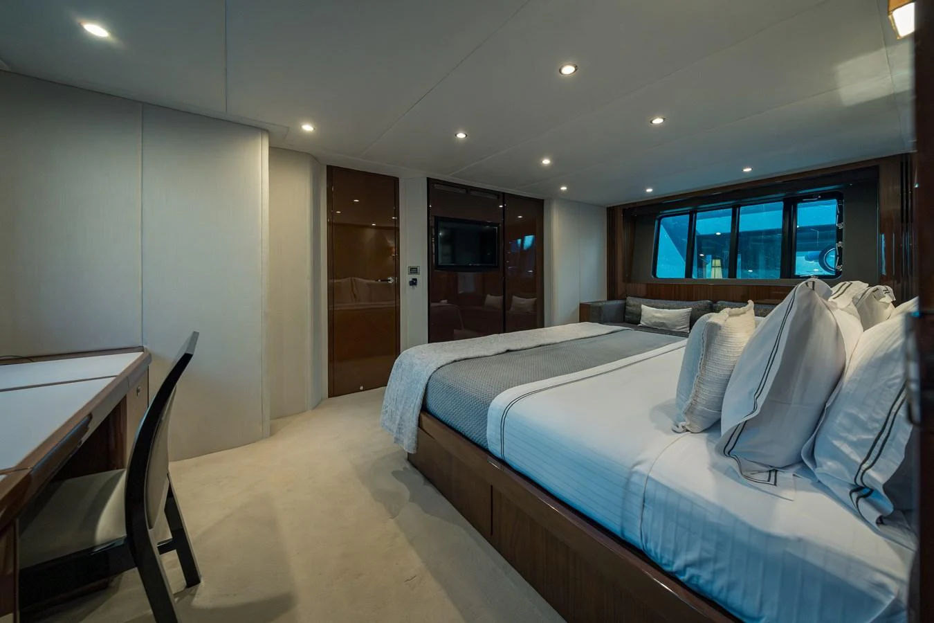 The master stateroom features a luxurious bed, sleek furnishings, and ample natural light. aboard 4 LIFE Yacht for Sale