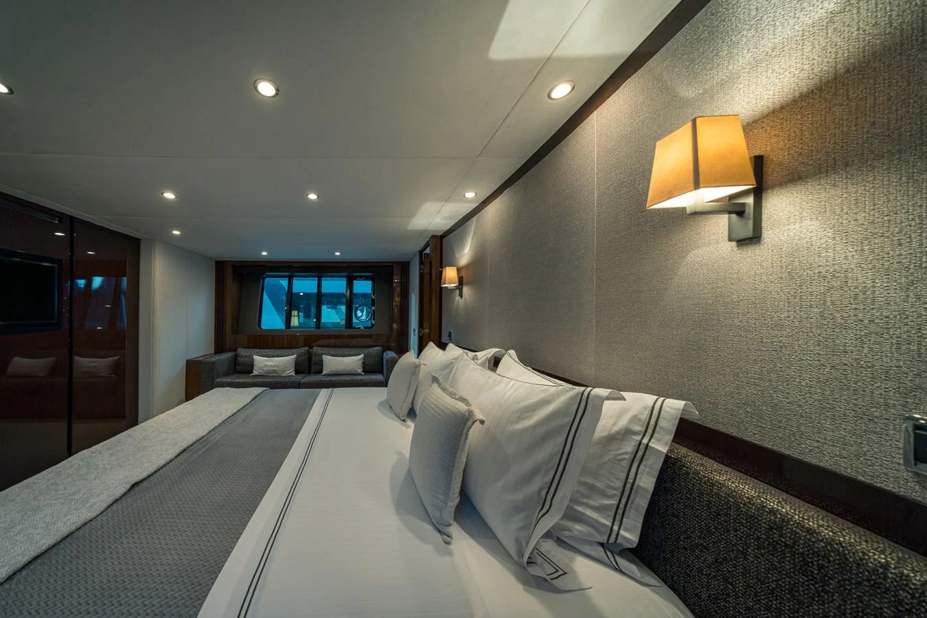 The stateroom features a luxurious bed with elegant bedding and ambient lighting. aboard 4 LIFE Yacht for Sale