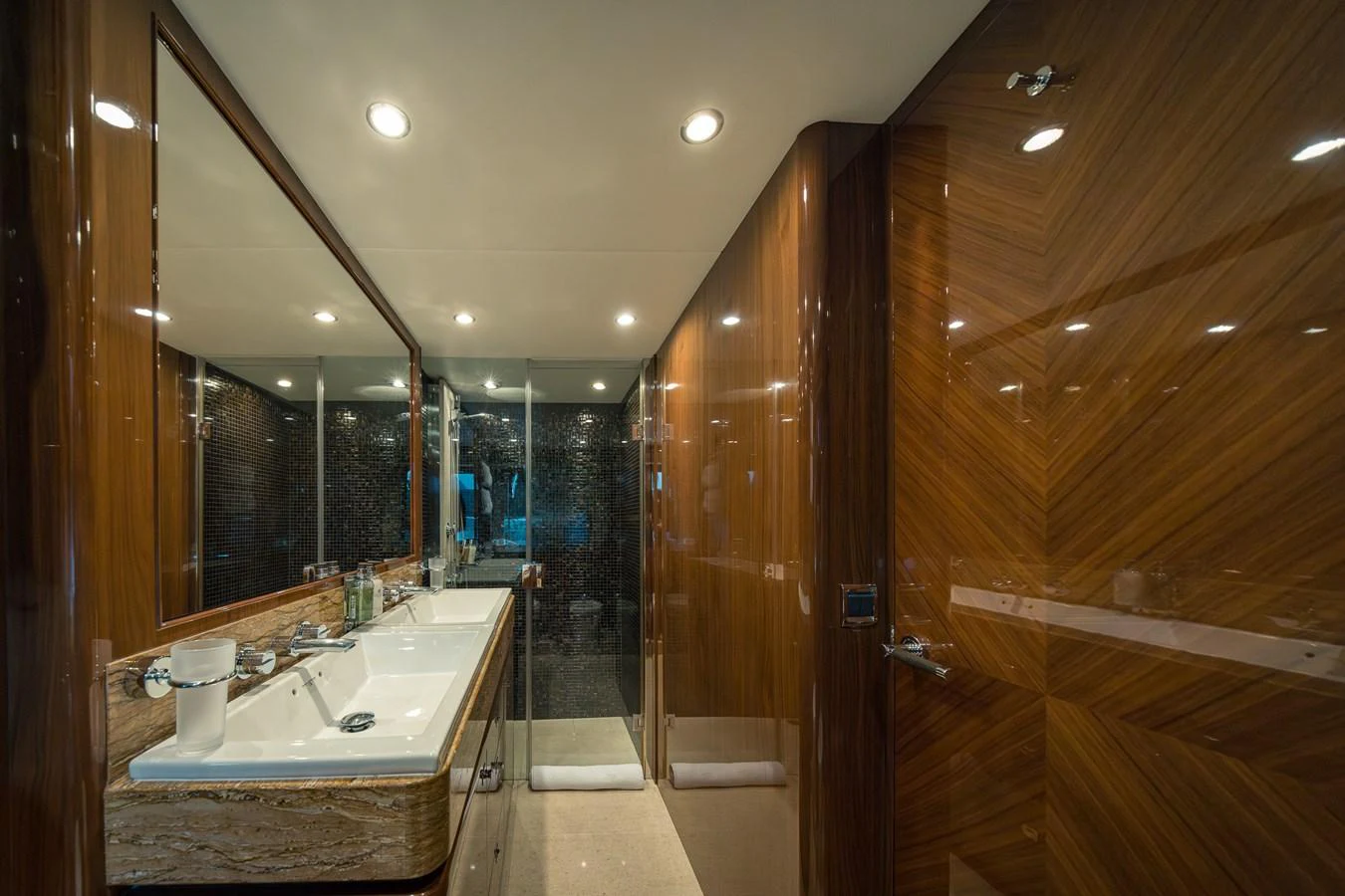 The yacht's bathroom features luxurious wood paneling and a spacious double sink area. aboard 4 LIFE Yacht for Sale