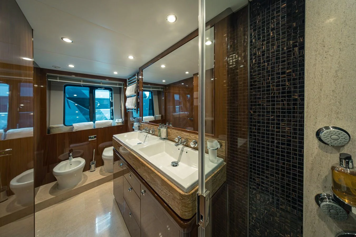 The yacht's bathroom features a double sink, bidet, and a spacious shower area with elegant finishes. aboard 4 LIFE Yacht for Sale