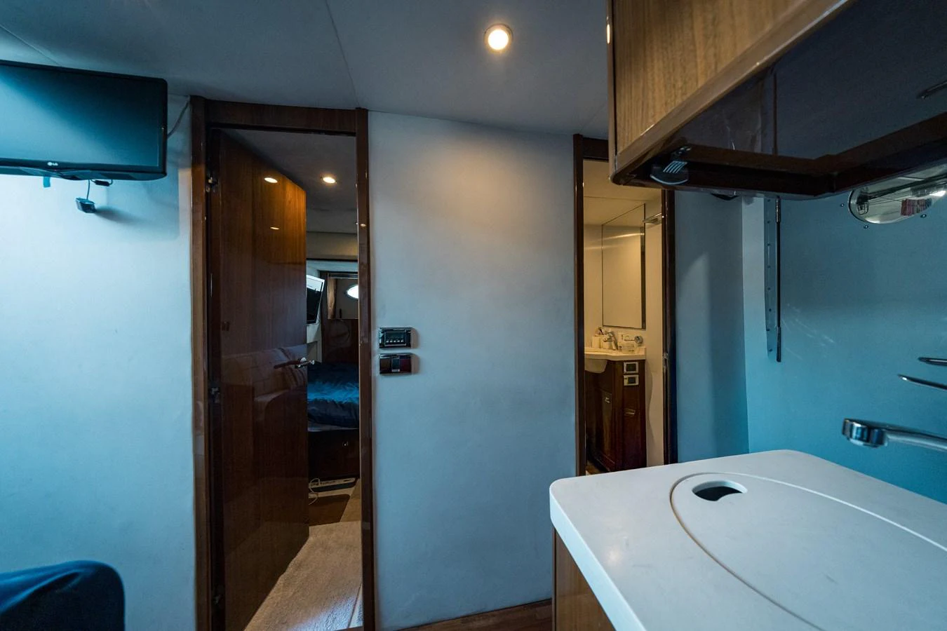 A cozy interior space featuring a small kitchenette and access to a bedroom and bathroom. aboard 4 LIFE Yacht for Sale