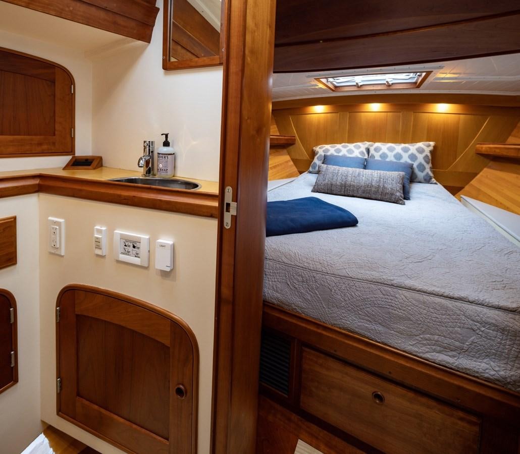 a bedroom with a bed and a sink aboard PRIVATE Yacht for Sale