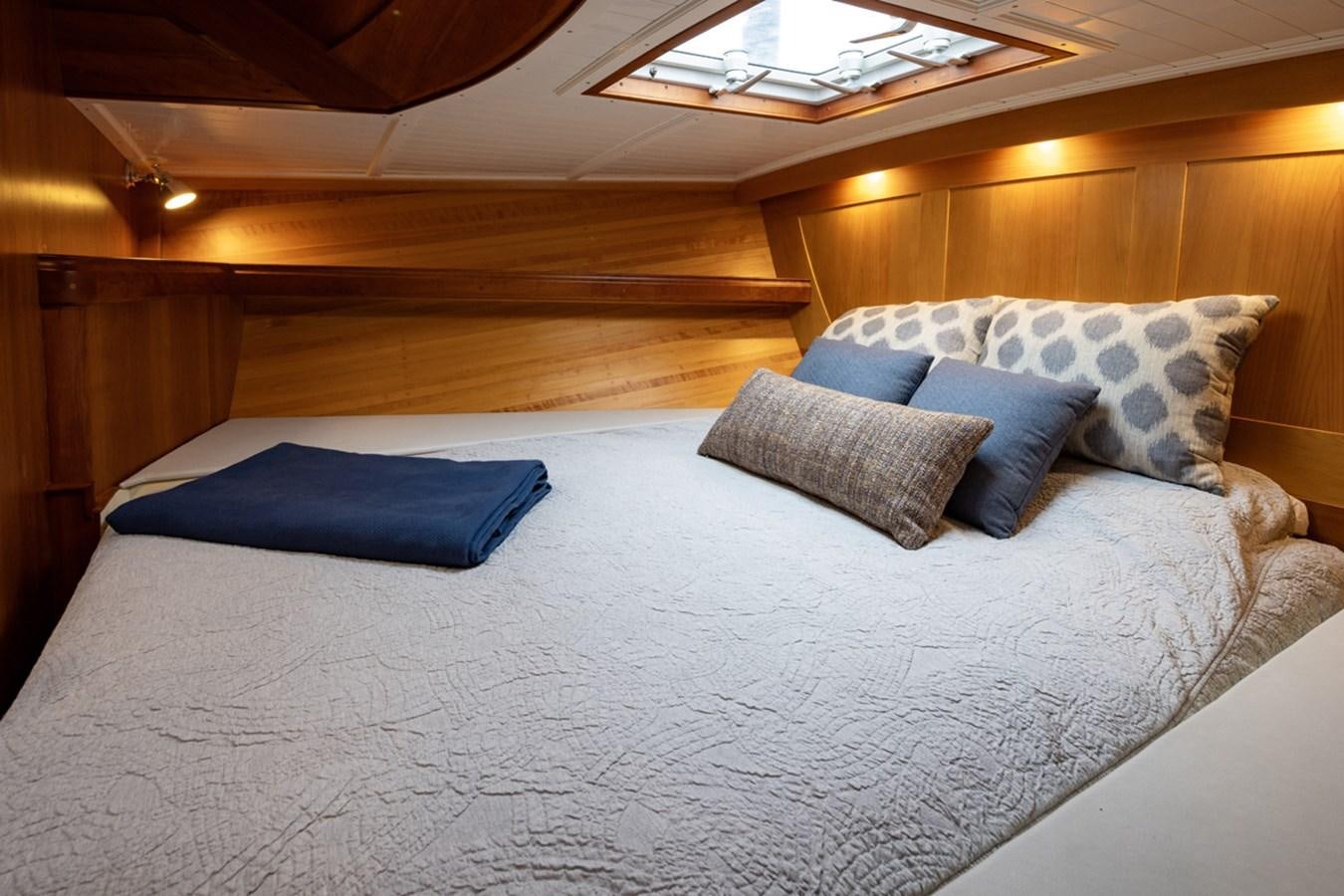 a bed with blue pillows aboard PRIVATE Yacht for Sale