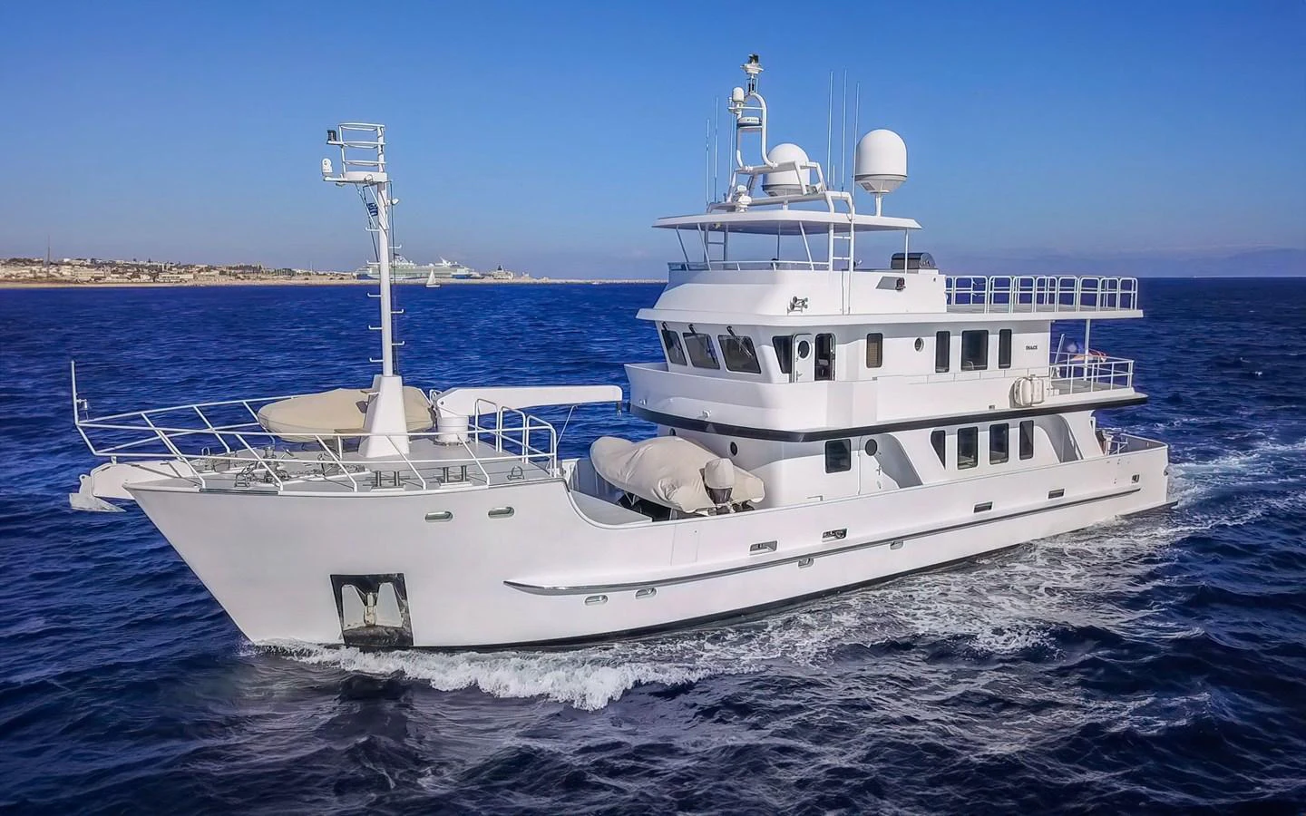 A sleek yacht cruises through the open water under a clear blue sky. aboard MISS SARAH J Yacht for Sale