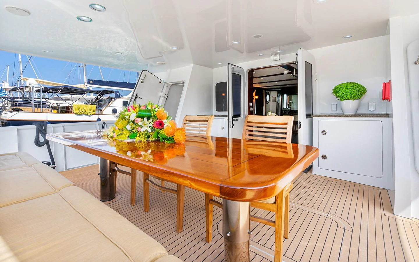 The aft deck features a polished wooden dining table with comfortable seating, perfect for alfresco dining. aboard MISS SARAH J Yacht for Sale