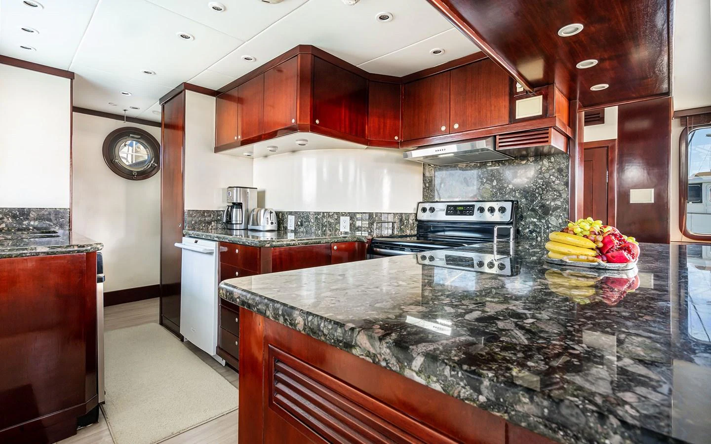 The yacht's galley features luxurious dark wood cabinetry and sleek granite countertops, creating an elegant and functional space. aboard MISS SARAH J Yacht for Sale