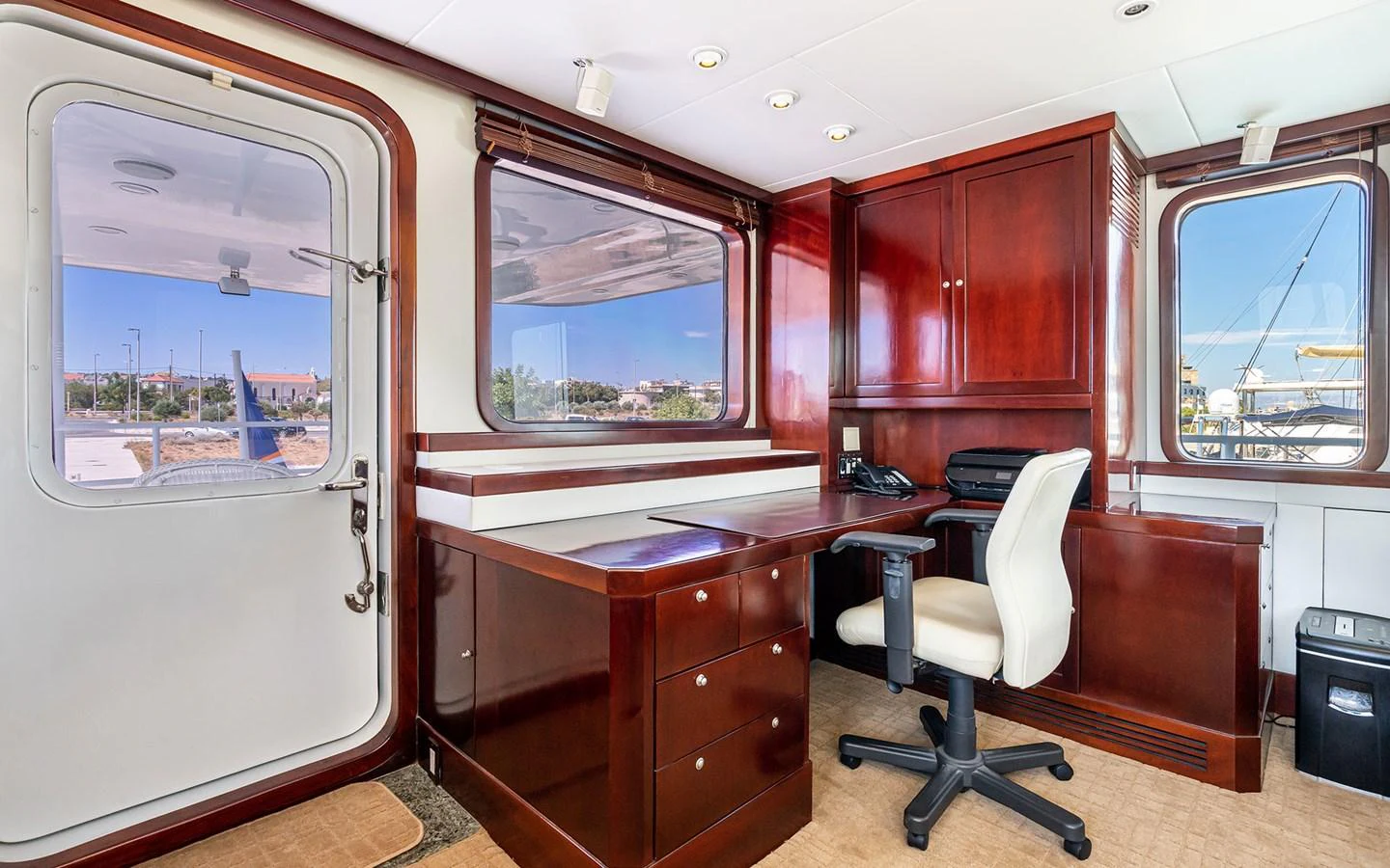 The yacht's office features elegant wood cabinetry and a comfortable workspace with a scenic view. aboard MISS SARAH J Yacht for Sale