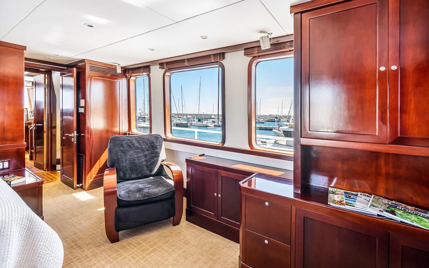 The yacht's interior features elegant wood cabinetry and large windows offering a view of the marina. aboard MISS SARAH J Yacht for Sale