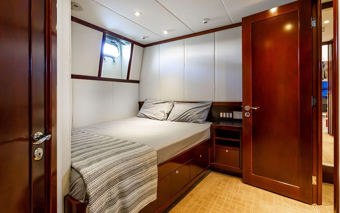 A cozy stateroom featuring a comfortable bed and elegant wooden finishes. aboard MISS SARAH J Yacht for Sale