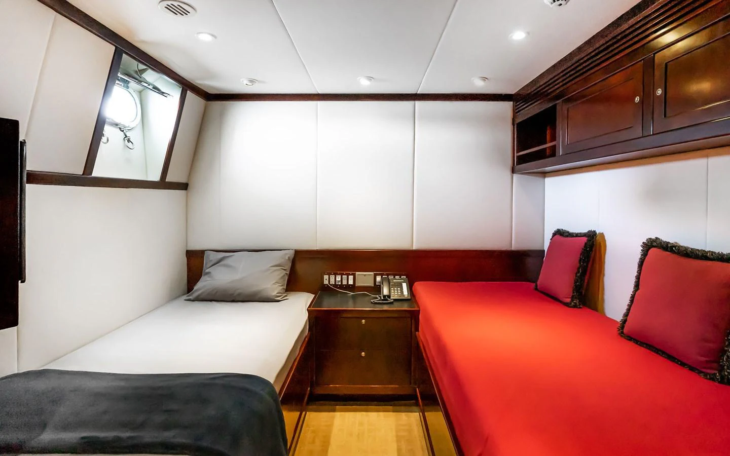 The guest stateroom offers a cozy and inviting space with twin beds and elegant wood finishes. aboard MISS SARAH J Yacht for Sale