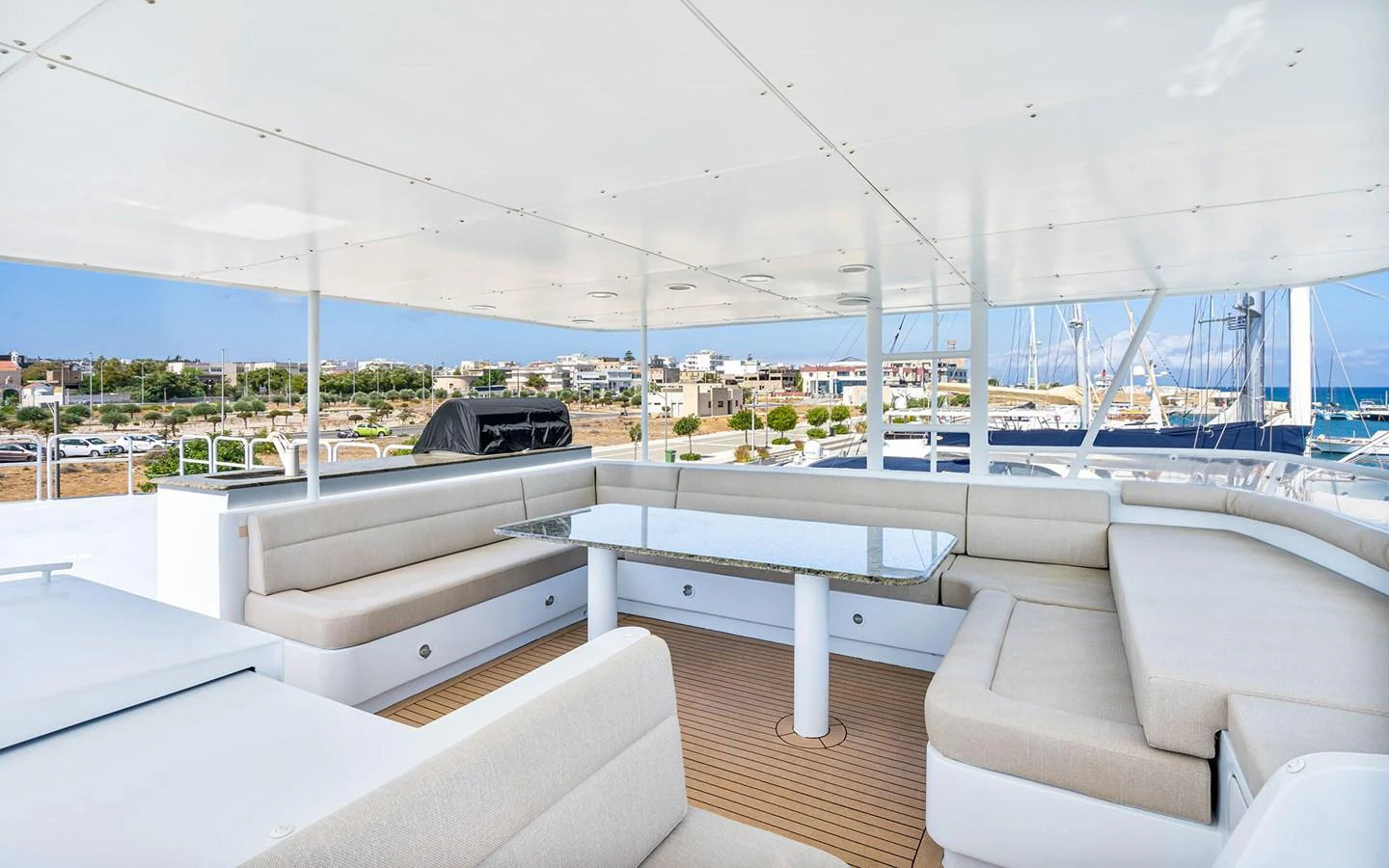 The sundeck features spacious seating with a central glass table, offering a perfect spot for relaxation and socializing. aboard MISS SARAH J Yacht for Sale