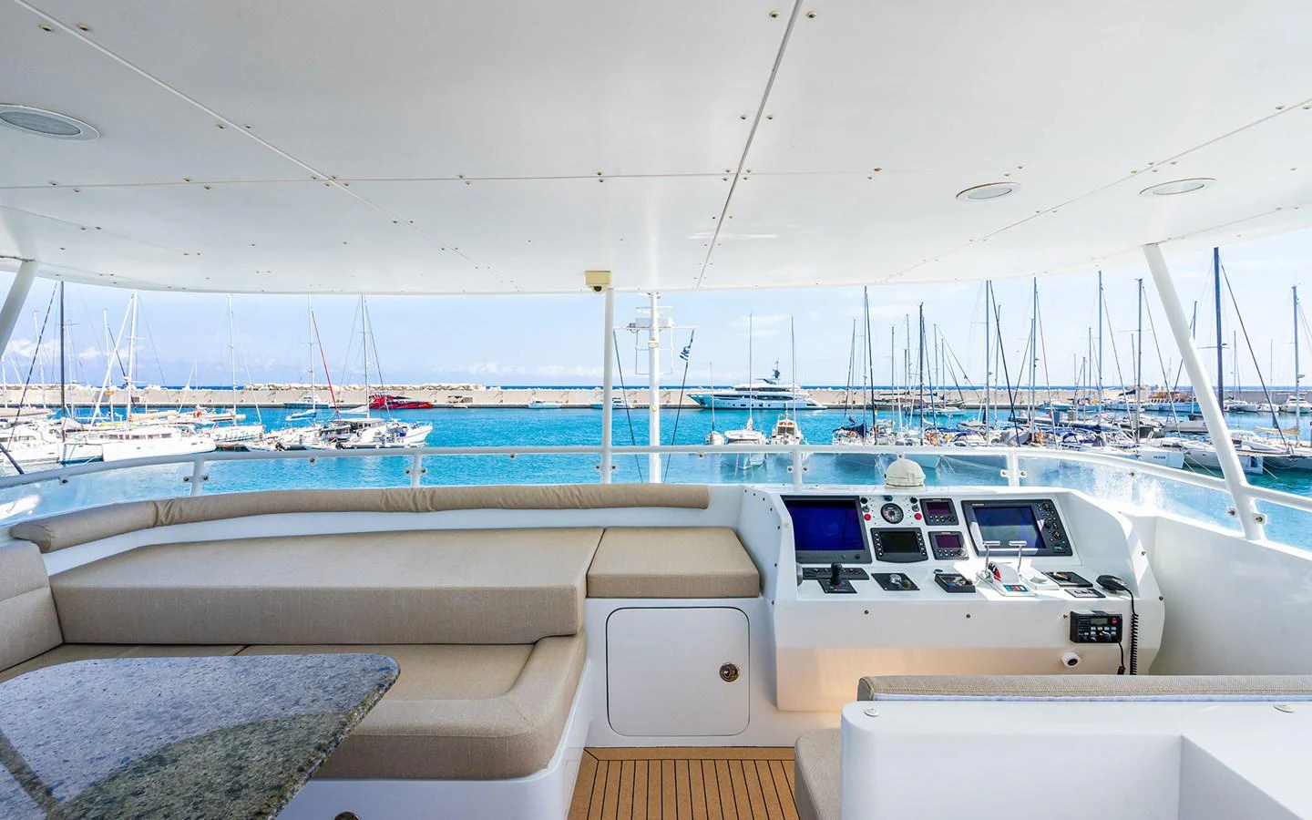 The flybridge offers a spacious seating area with a view of the marina, featuring a helm station equipped with modern navigation instruments. aboard MISS SARAH J Yacht for Sale