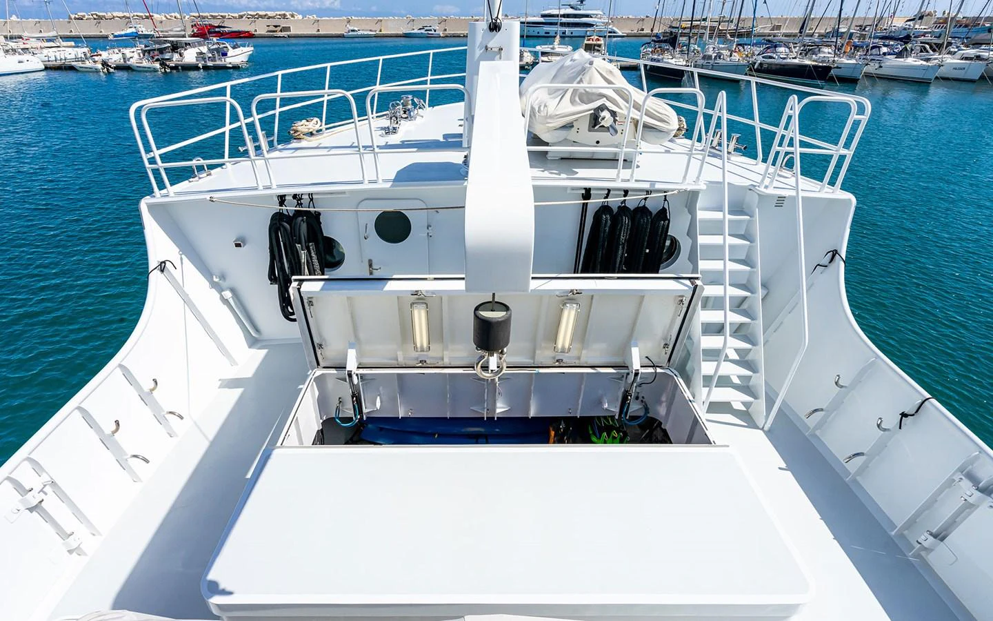 The yacht's deck offers a spacious and well-equipped area for various activities, with a view of the marina in the background. aboard MISS SARAH J Yacht for Sale