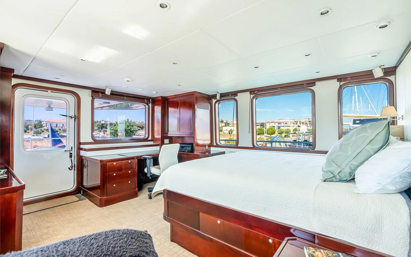 The master stateroom features a spacious layout with elegant wood finishes and large windows offering stunning views. aboard MISS SARAH J Yacht for Sale