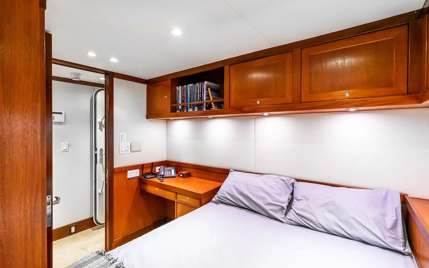 A cozy stateroom featuring a comfortable bed, wooden cabinetry, and modern lighting. aboard MISS SARAH J Yacht for Sale
