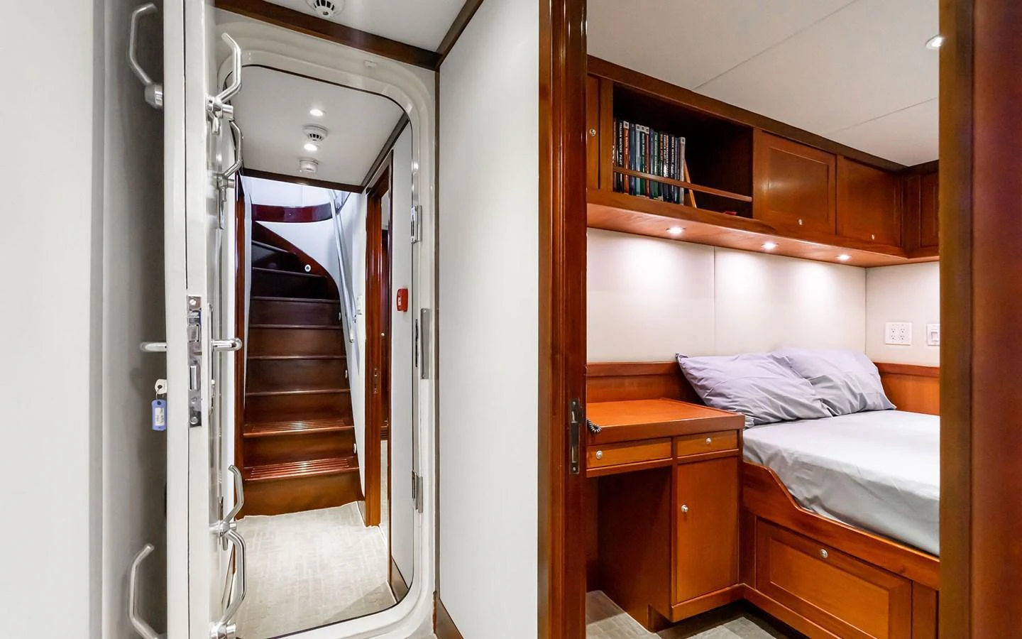 A cozy cabin with a comfortable bed and wooden furnishings, adjacent to a stairway. aboard MISS SARAH J Yacht for Sale