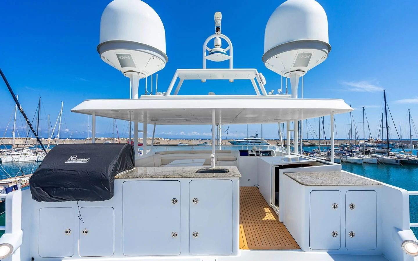 The flybridge offers a spacious and well-equipped area for relaxation and entertainment with a stunning marina backdrop. aboard MISS SARAH J Yacht for Sale