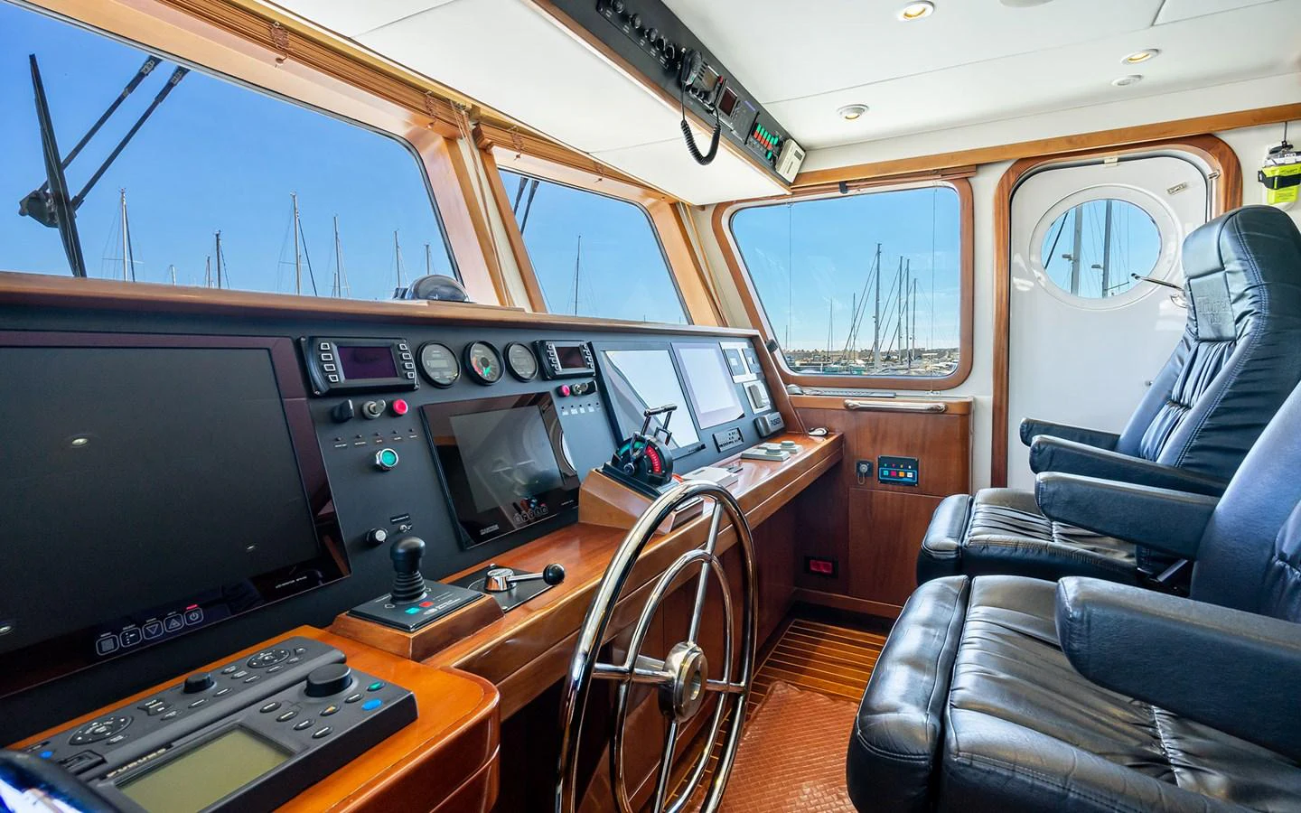 The helm station features advanced navigation equipment and luxurious seating, offering a commanding view of the surroundings. aboard MISS SARAH J Yacht for Sale