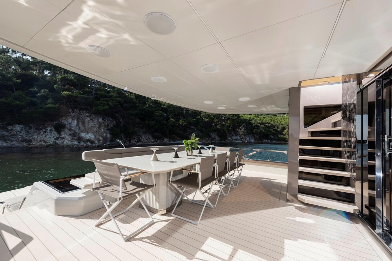 a room with a table and chairs aboard MAZU 82 Yacht for Sale