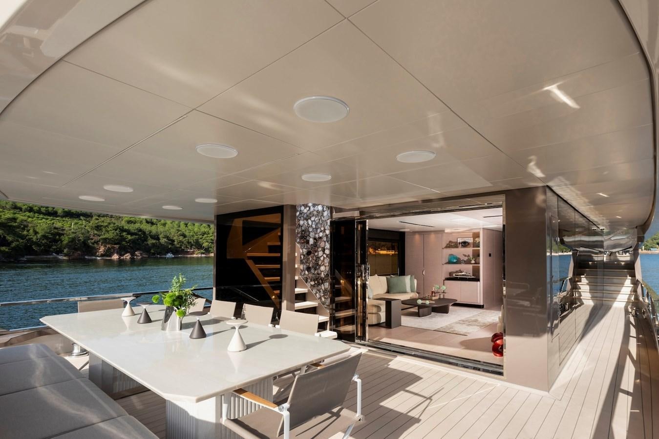 a room with a table and chairs aboard MAZU 82 Yacht for Sale