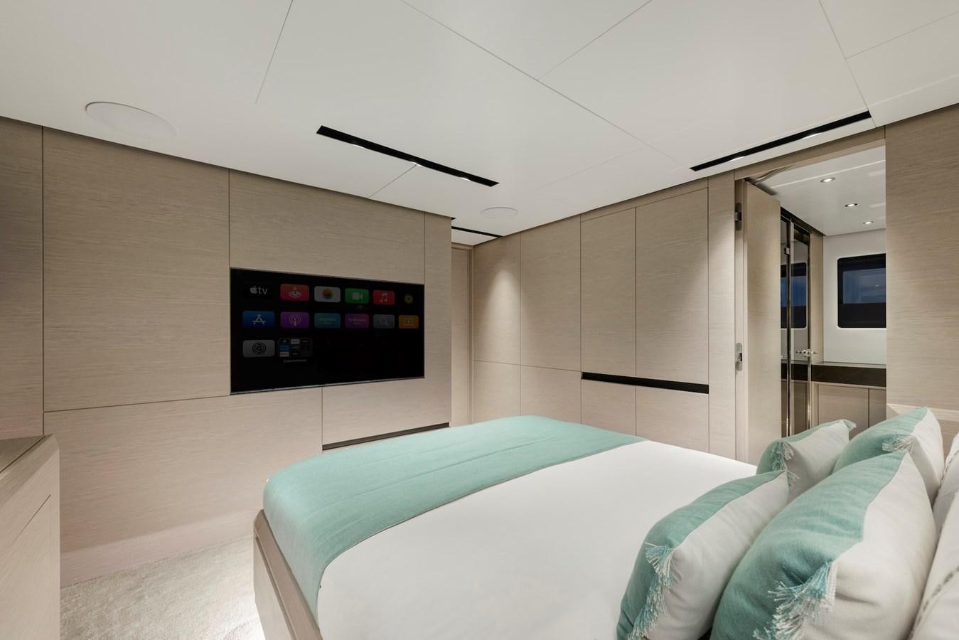a room with a bed and a tv on the wall aboard MAZU 82 Yacht for Sale