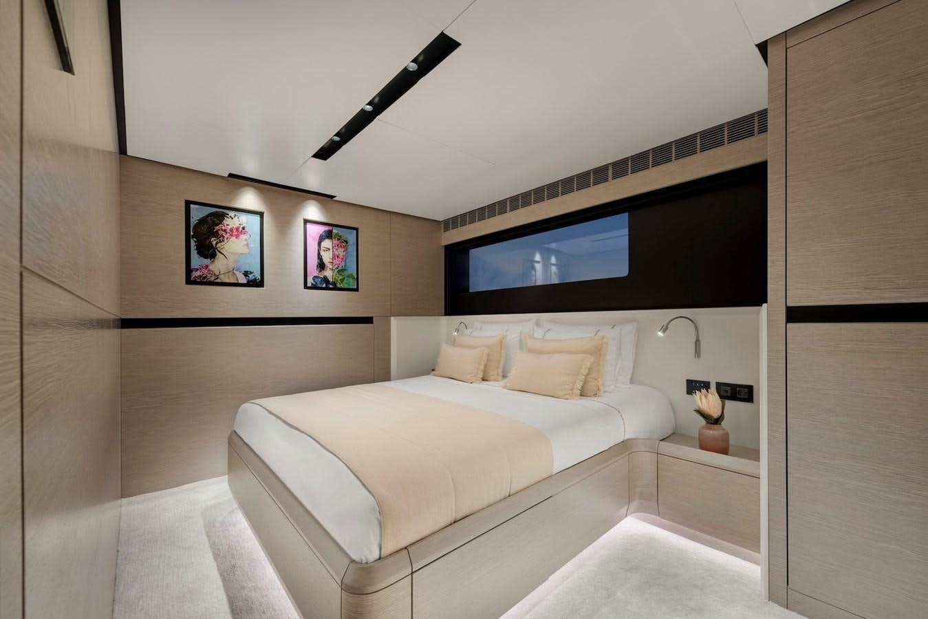 a bedroom with a bed and a tv on the wall aboard MAZU 82 Yacht for Sale