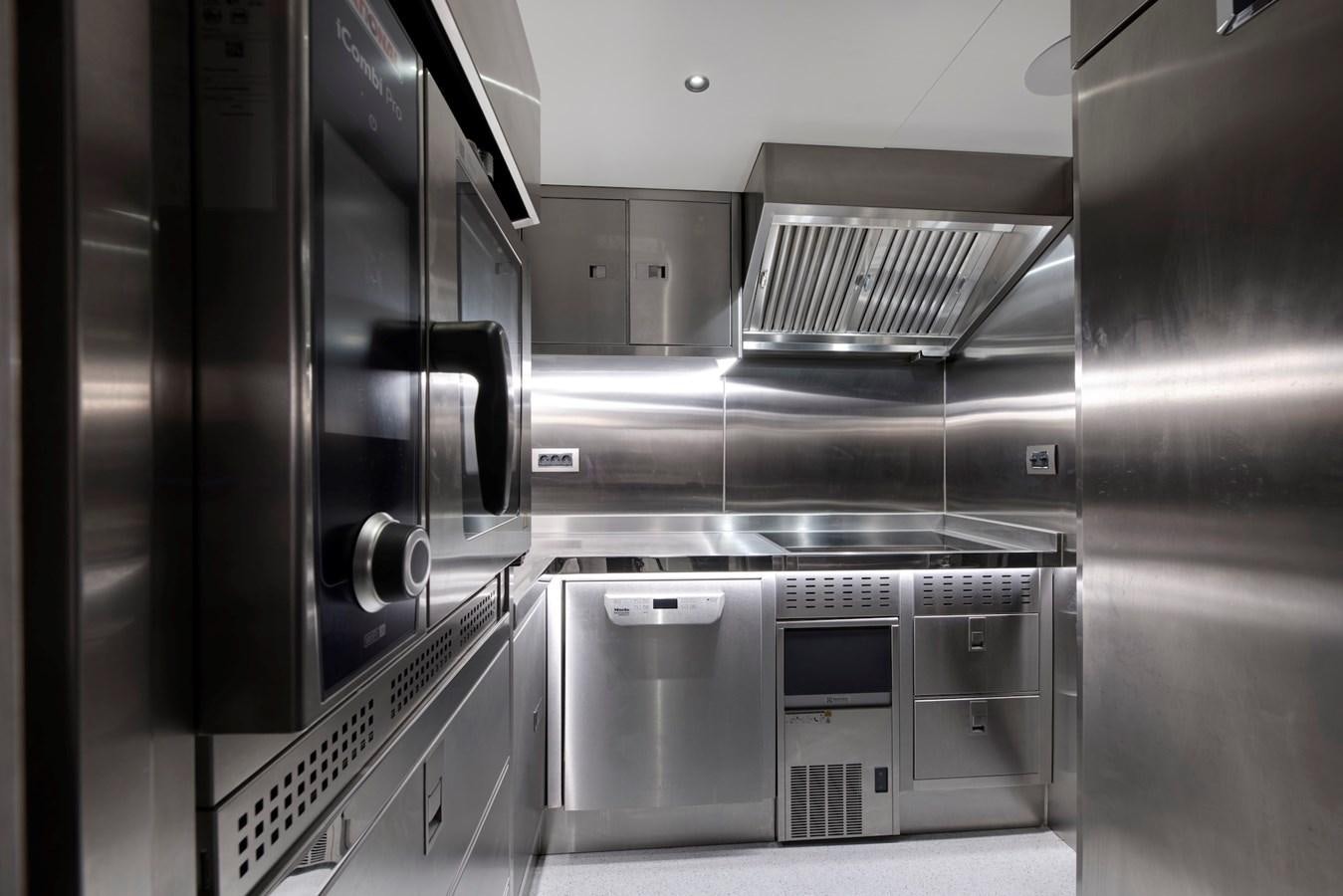 a kitchen with stainless steel appliances aboard MAZU 82 Yacht for Sale