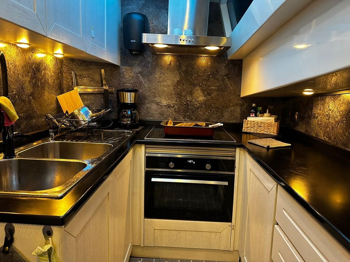 a kitchen with a stove and sink aboard CONAM 65 FLYBRIDGE Yacht for Sale