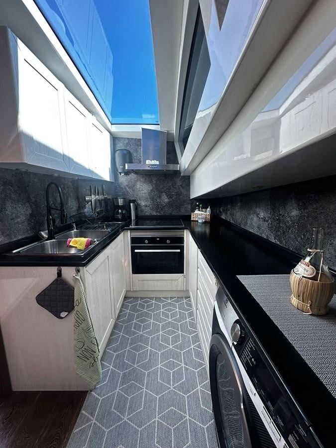 a kitchen with blue cabinets aboard CONAM 65 FLYBRIDGE Yacht for Sale