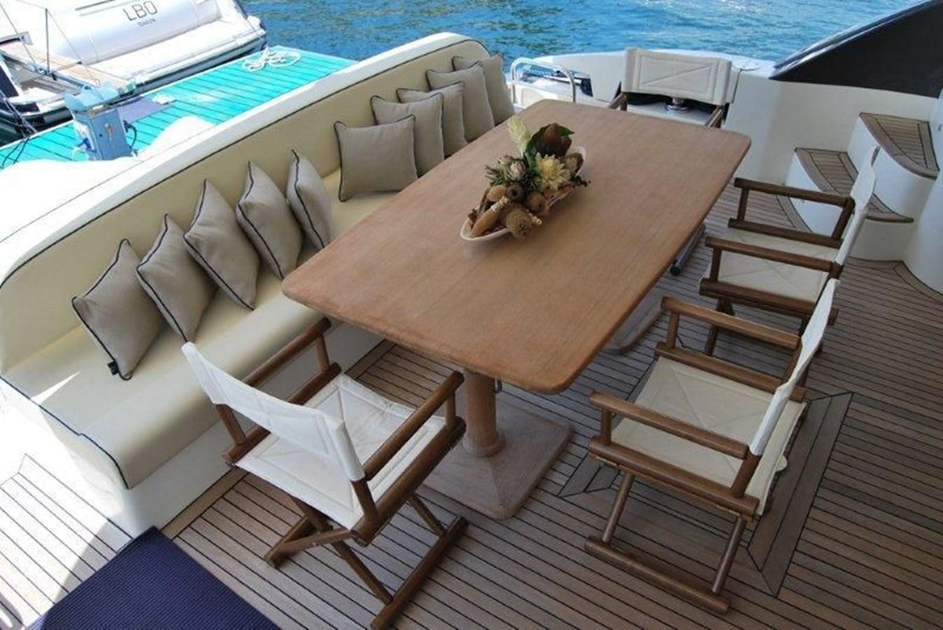 a table with chairs around it aboard CONAM 65 FLYBRIDGE Yacht for Sale